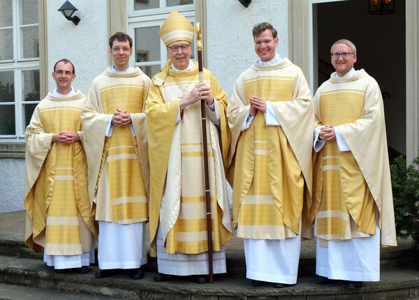 Bischof Trelle freut sich mit den vier neuen Priestern.