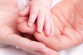 Hand von Eltern und Kleinkind liegen ineinander