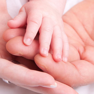 Hand von Eltern und Kleinkind liegen ineinander