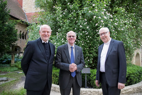 Der 1000-jährige Rosenstock zeigt sich zum Besuch des Präsidenten des Deutschen Bundestages, Prof. Dr. Norbert Lammert (Mitte), in voller Blütenpracht. Eingerahmt wird der Spitzenpolitiker von Landessuperintendent Eckard Gorka (links) und Bischof Norbert Trelle.