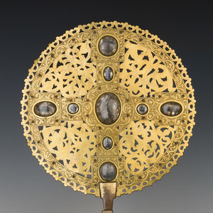 Goldenes Scheibenkreuz aus Domschatz vor schwarzem Hintergrund, ausgestellt im Dommuseum.