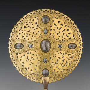 Goldenes Scheibenkreuz aus Domschatz vor schwarzem Hintergrund, ausgestellt im Dommuseum.