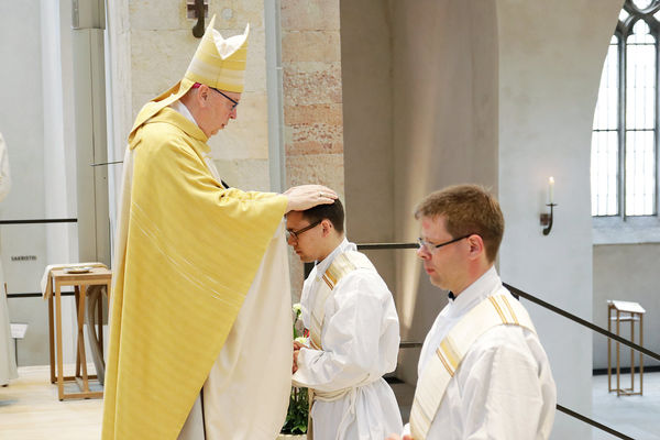 Bischof Norbert Trelle weiht Fabian Boungard und Benedikt Heimann (rechts) zu Priestern.