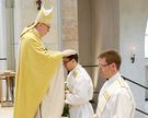 Bischof Norbert Trelle weiht Fabian Boungard und Benedikt Heimann (rechts) zu Priestern.