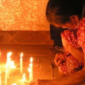 Bolivianerin beim Anzünden von Gebetskerzen