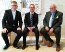 Domkapitular Martin Wilk, Jörg Bartels, Präsident des Lions-Club Hildesheim, und der Vorsitzende des Dombauvereins, Dr. Konrad Deufel, nehmen auf einer neuen Bank im Dommuseum Platz.