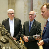 Dr. Gerhard Lutz (rechts) vom Dommuseum Hildesheim stellt Bundestagspräsident Norbert Lammert das spätromanische Taufbecken im Dom vor. Bischof Norbert Trelle (links) hört zu.