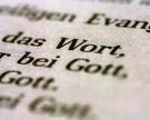 Eine Bibel liegt aufgeschlagen auf einem Tisch. Es sind die Worte "Wort" und "Gott" zu lesen.