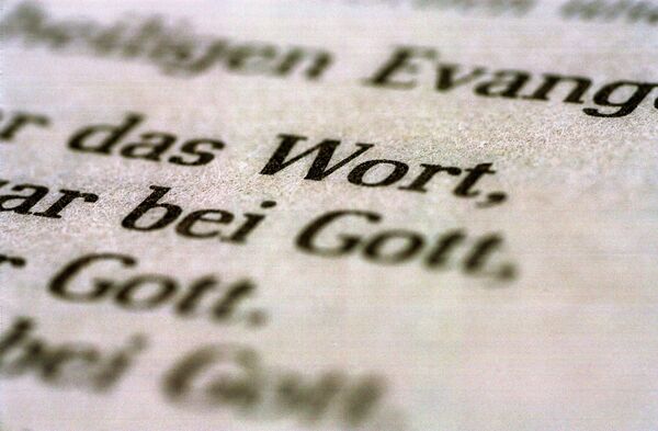 Eine Bibel liegt aufgeschlagen auf einem Tisch. Es sind die Worte "Wort" und "Gott" zu lesen.