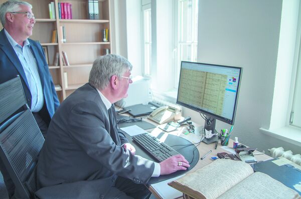 Statt mühselig in alten Kirchenbüchern zu blättern, kann man nun unkompliziert am PC Namen suchen und forschen. Generalvikar Weihbischof Heinz-Günter Bongartz probiert im Bistumsarchiv die neuen Möglichkeiten aus.