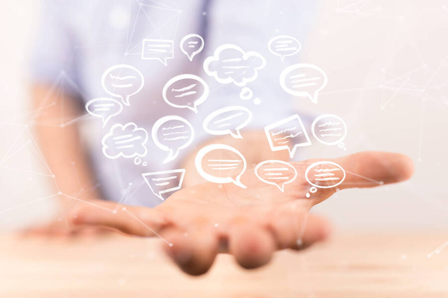 Über einer Hand schweben Sprechblasen