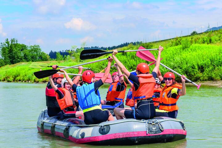 Eine Gruppe in einem Schlauchboot auf einem Fluss. 