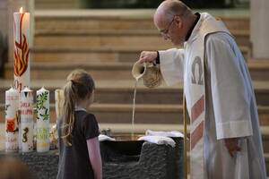 Priester bereitet das Taufbecken für bevorstehende Taufe vor