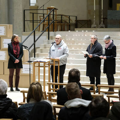 Betroffene und Mitarbeiterinnen und Mitarbeiter der Stabsstelle Prävention, Intervention und Aufarbeitung eröffnen die Gedenkfeier vor den Stufen zum Altarraum des Hildesheimer Domes