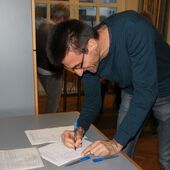 Volker Köhler unterzeichnet im Gemeindesaal die Ökumene-Erklärung
