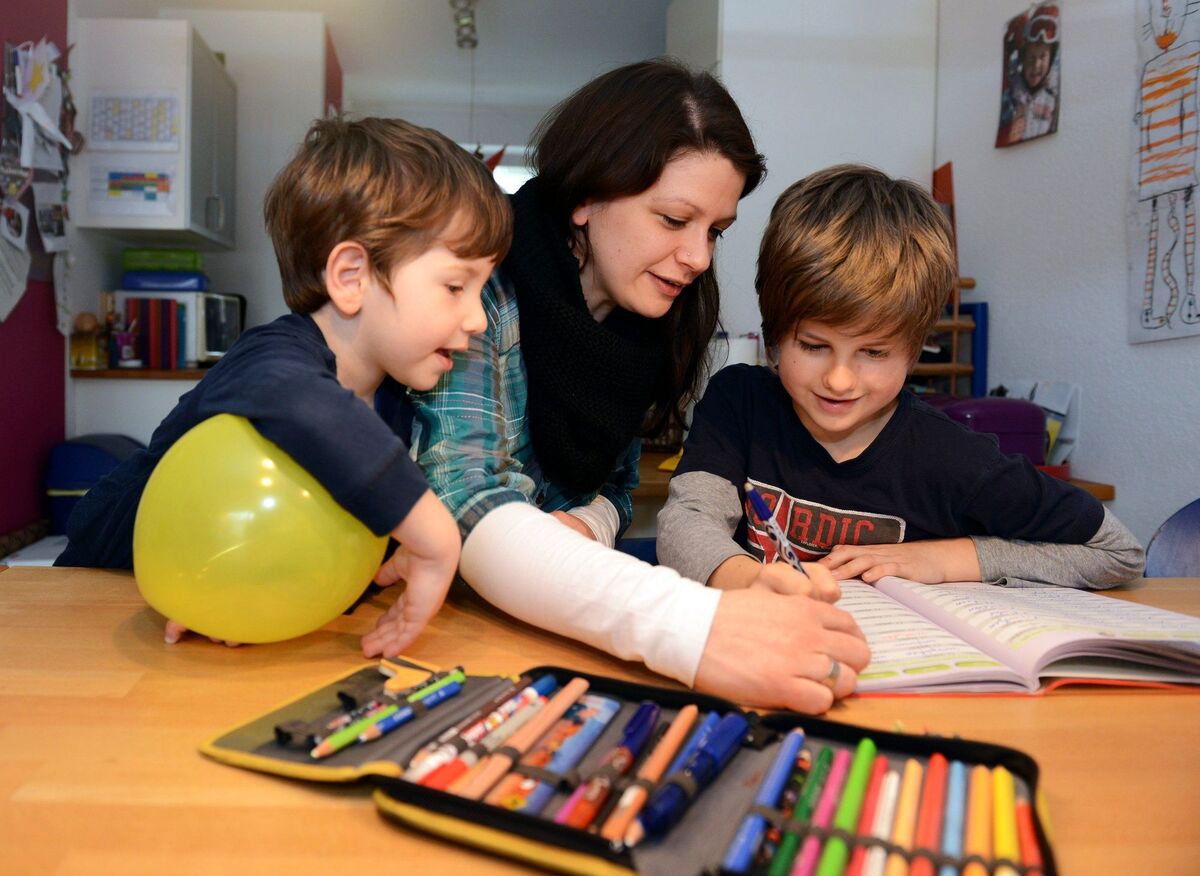 Mutter hilft ihrem Sohn bei Hausaufgabe