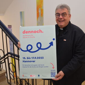 Monsignore Georg Austen, Generalsekretär des Bonifatiuswerkes, präsentiert das Plakat zur "dennoch-Konferenz".