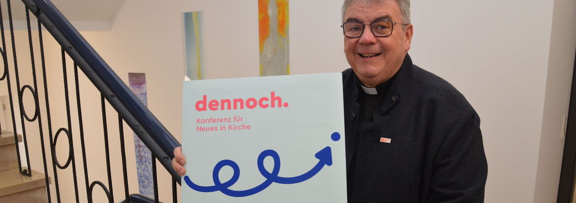 Monsignore Georg Austen, Generalsekretär des Bonifatiuswerkes, präsentiert das Plakat zur "dennoch-Konferenz".