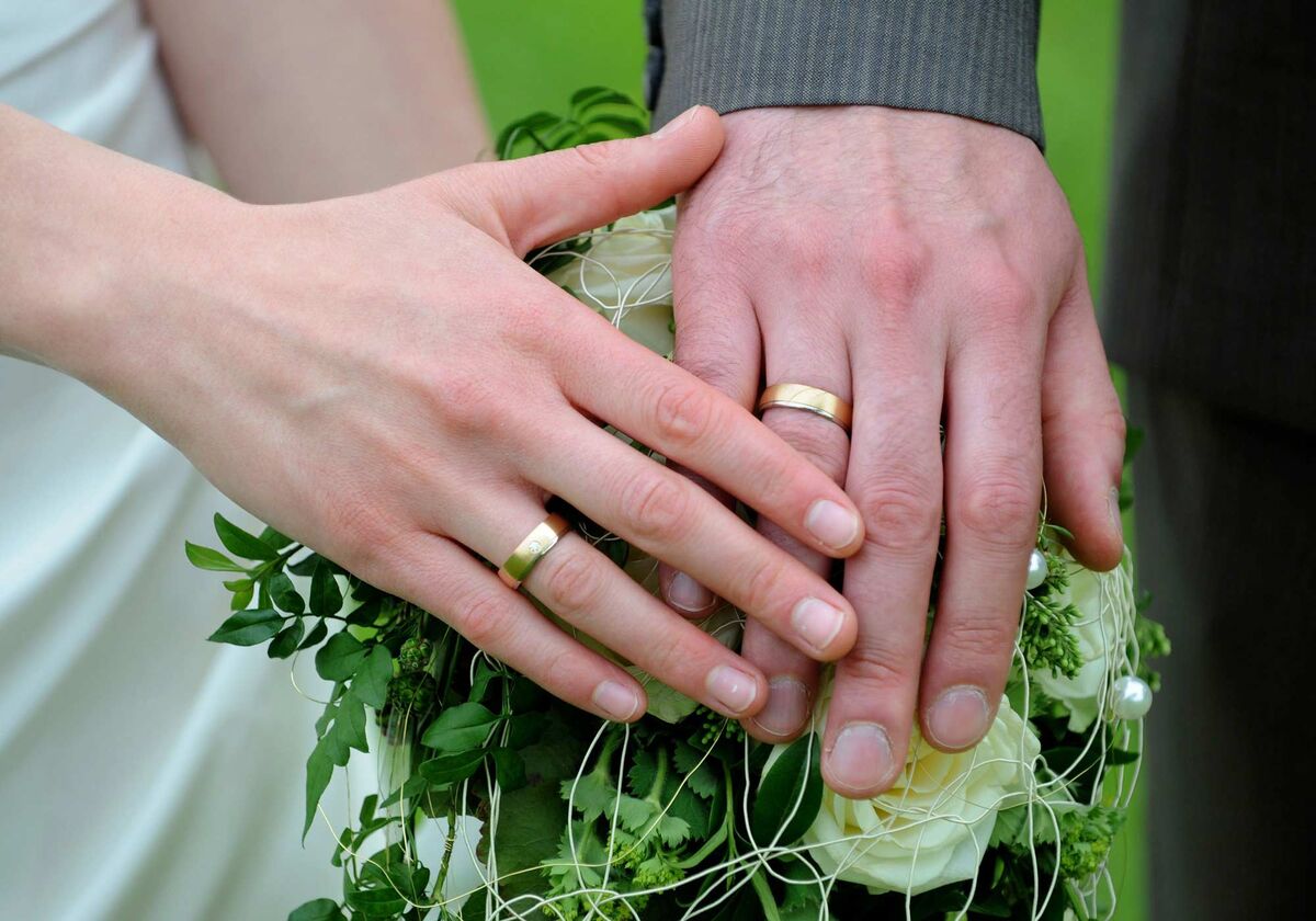 Brautpaar hält Hände mit Eheringen