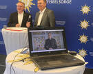 Torsten Thiel und Joachim Michalik lauschen den Worten von Bischof Dr. Heiner Willmer SCJ, der per Video die Teilnehmer der virtuellen Tagung grüßte.