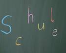 Bunter Schriftzug "Schule" auf Tafel
